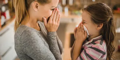 Mother showing her daughter how to stop a nosebleed