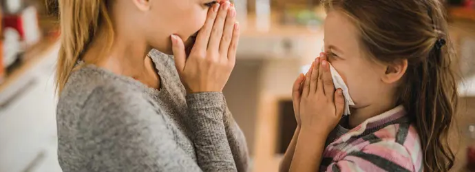 Mother showing her daughter how to stop a nosebleed