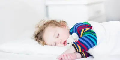 Toddler girl sleeping on a bed