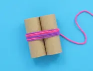 Two toilet roll tubes, side by side, wrapped together around the middle with pink and purple wool.