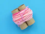 More layers of pink wool are wrapped around the tubes forming a 3 cm thick loop tied into place with a pink wool string.